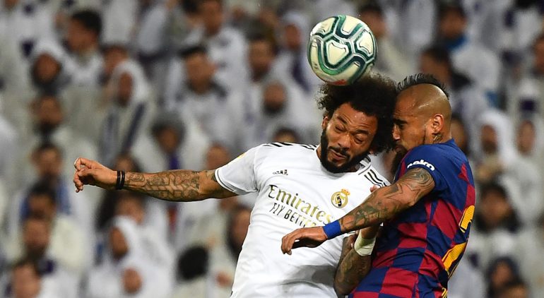 TOPSHOT - Barcelona's Chilean midfielder Arturo Vidal (R) heads the ball with Real Madrid's Brazilian defender Marcelo during the Spanish League football match between Real Madrid and Barcelona at the Santiago Bernabeu stadium in Madrid on March 1, 2020. (Photo by GABRIEL BOUYS / AFP) (Photo by GABRIEL BOUYS/AFP via Getty Images)